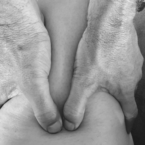 Therapist's hands performing a massage and body scrub treatment for men at The Men's Grooming Salon in Sydney.